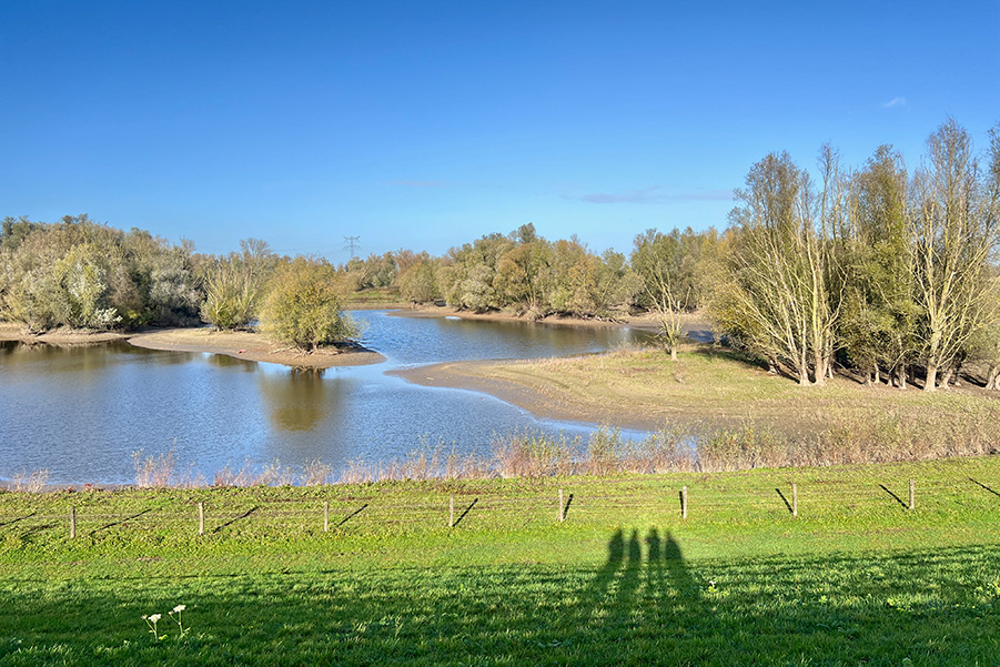 Schaduw van wandelaars op de Walk of Wisdom, op de dijk bij Deest